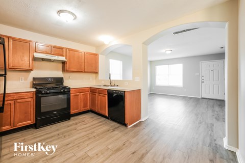 A kitchen with wooden cabinets and a black stove top oven.