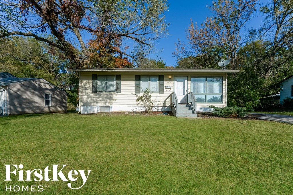 a small white house with a lawn in front of it
