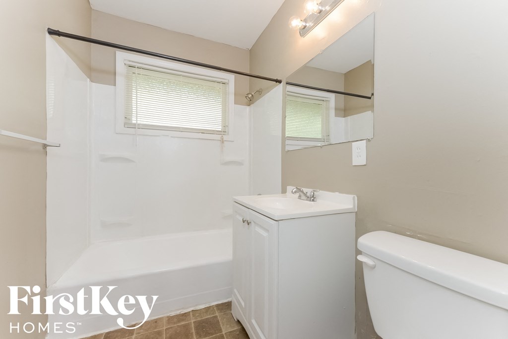 a bathroom with a toilet sink and a tub and a mirror