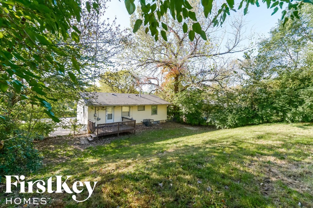 a small yellow house in the middle of a grassy yard