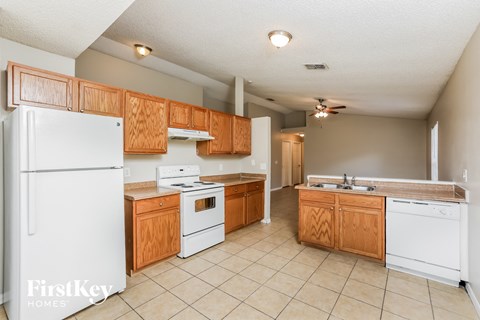 A kitchen with wooden cabinets and white appliances.
