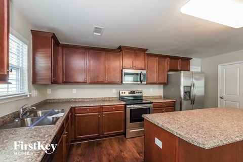a kitchen with wooden cabinets and granite counter tops and stainless steel appliances