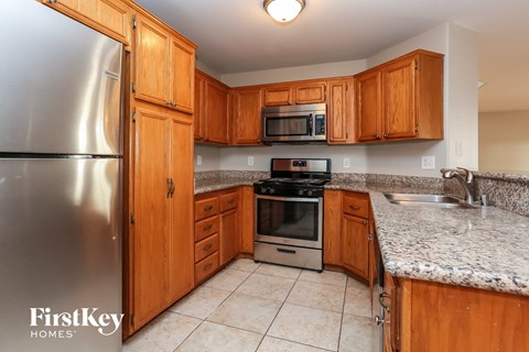 A kitchen with wooden cabinets and a granite countertop.