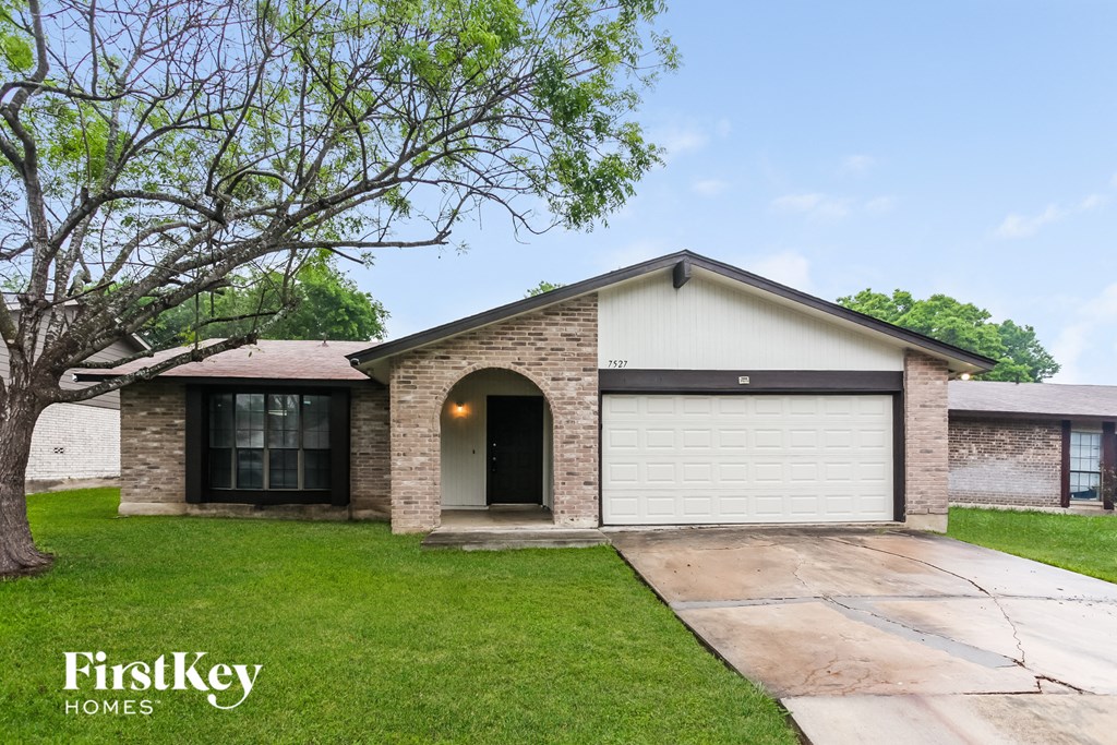 front view of a brick house with a white garage door