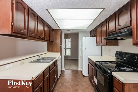 a kitchen with wood cabinets and white counter tops and black appliances