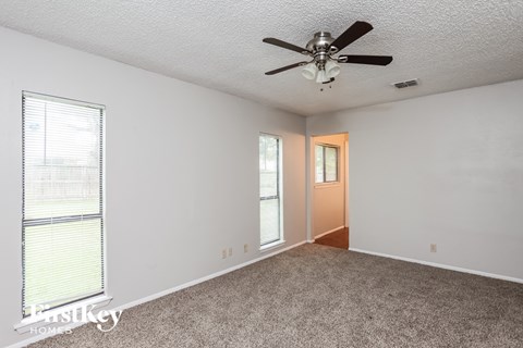 a living room with carpet and a ceiling fan