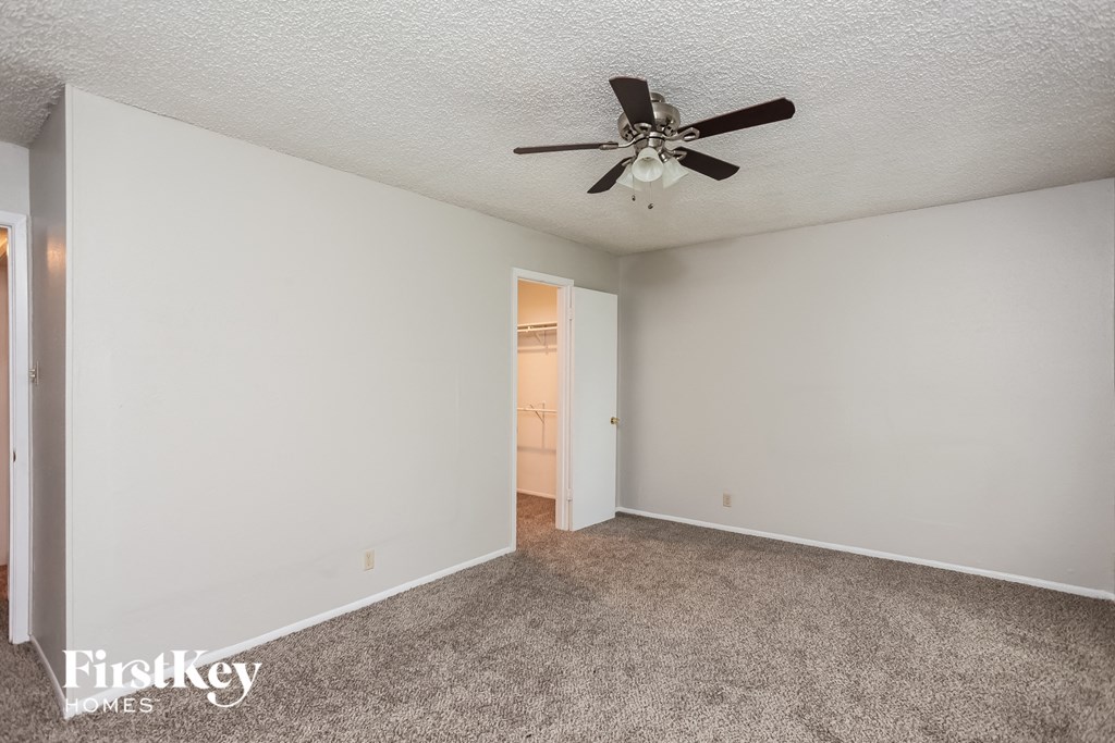 a living room with carpet and a ceiling fan