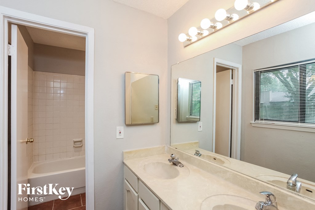 a bathroom with a large mirror and a sink and a tub
