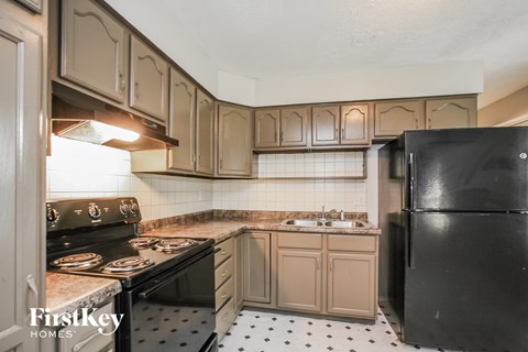 a kitchen with white cabinets and black appliances and a black refrigerator