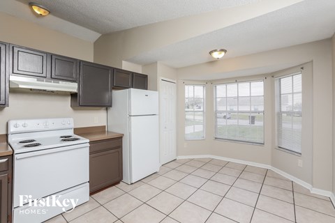A kitchen with a white stove and a white refrigerator.