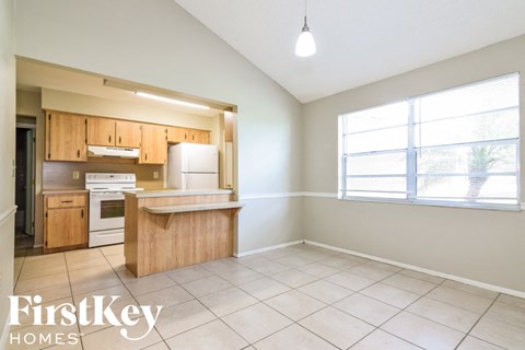 A kitchen with wooden cabinets and a white refrigerator is shown.