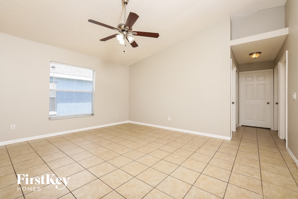 A spacious room with a ceiling fan and tiled floor.