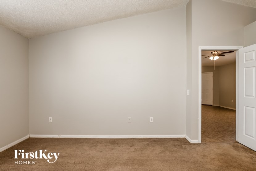 A room with a carpeted floor and a doorway leading to another room.