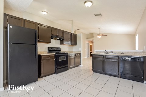 the kitchen is clean and ready to use with stainless steel appliances and black appliances