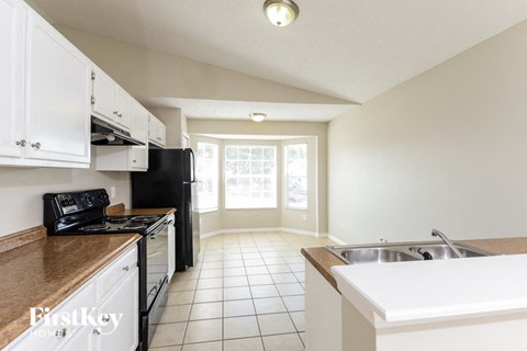 a kitchen with white cabinets and black appliances and a sink