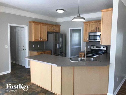 A kitchen with wooden cabinets and a grey counter top.