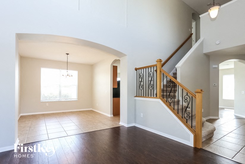 A spacious living room with a staircase leading to the upper floor.