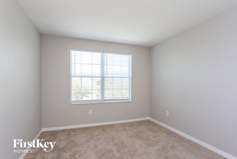 A room with a window and carpeted floor.