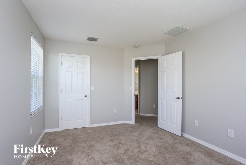 A room with two doors and a carpeted floor.