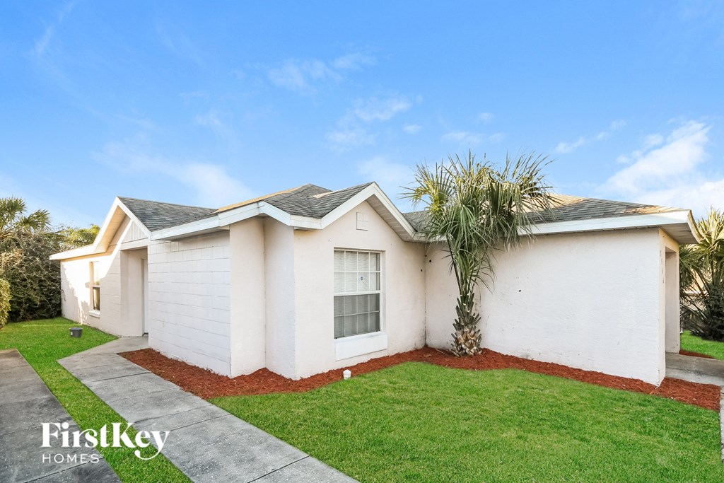 a white house with a palm tree in front of it