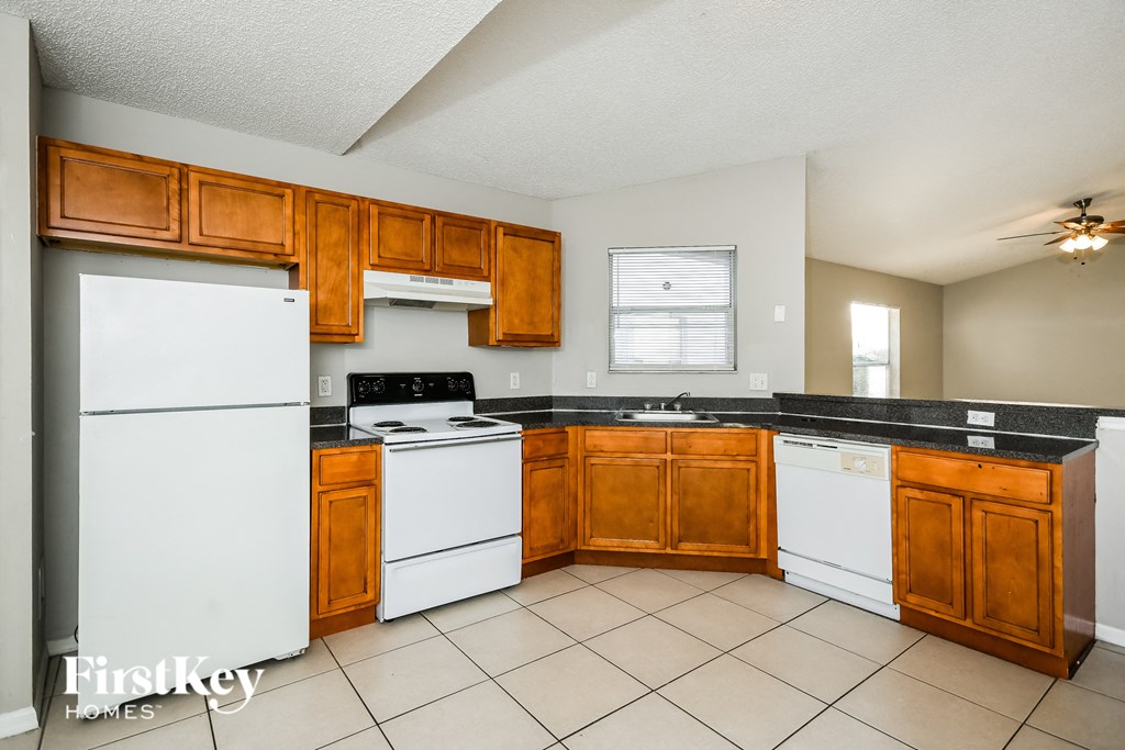 a kitchen with white appliances and wooden cabinets