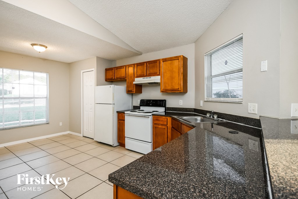 a kitchen with granite counter tops and white appliances