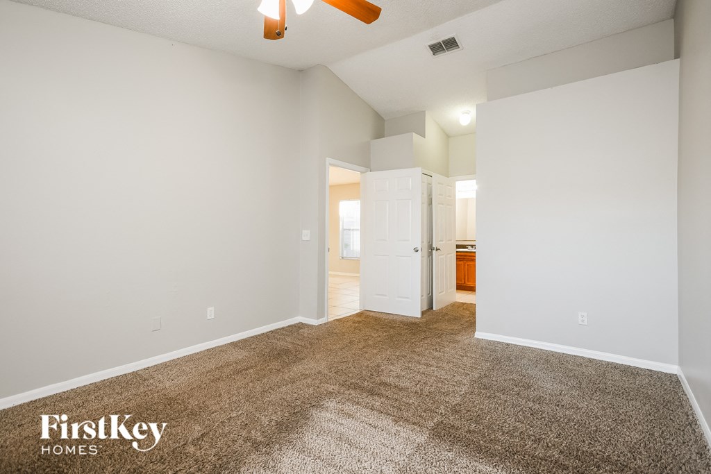 a spacious living room with carpet and white walls
