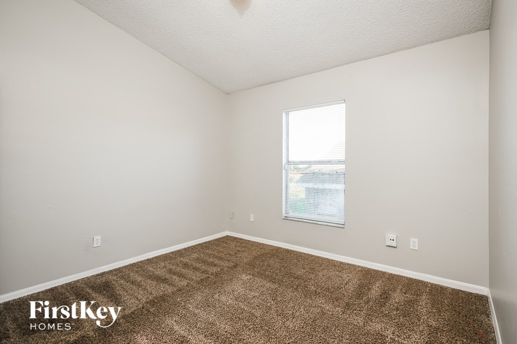 a bedroom with carpet and a window
