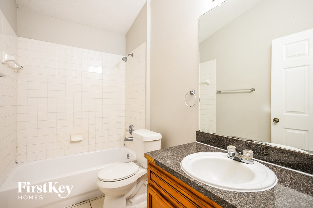 a bathroom with a sink toilet and shower and a mirror
