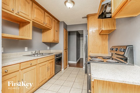 A kitchen with wooden cabinets and a stainless steel refrigerator.