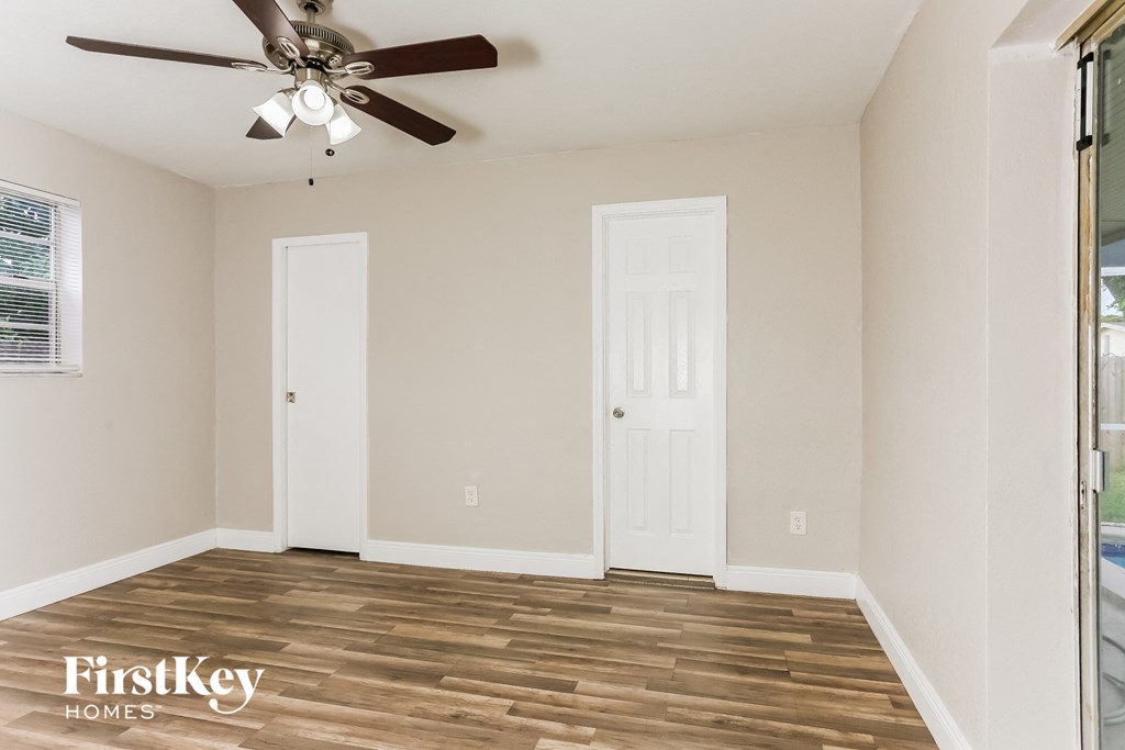 the living room of an empty house with a ceiling fan