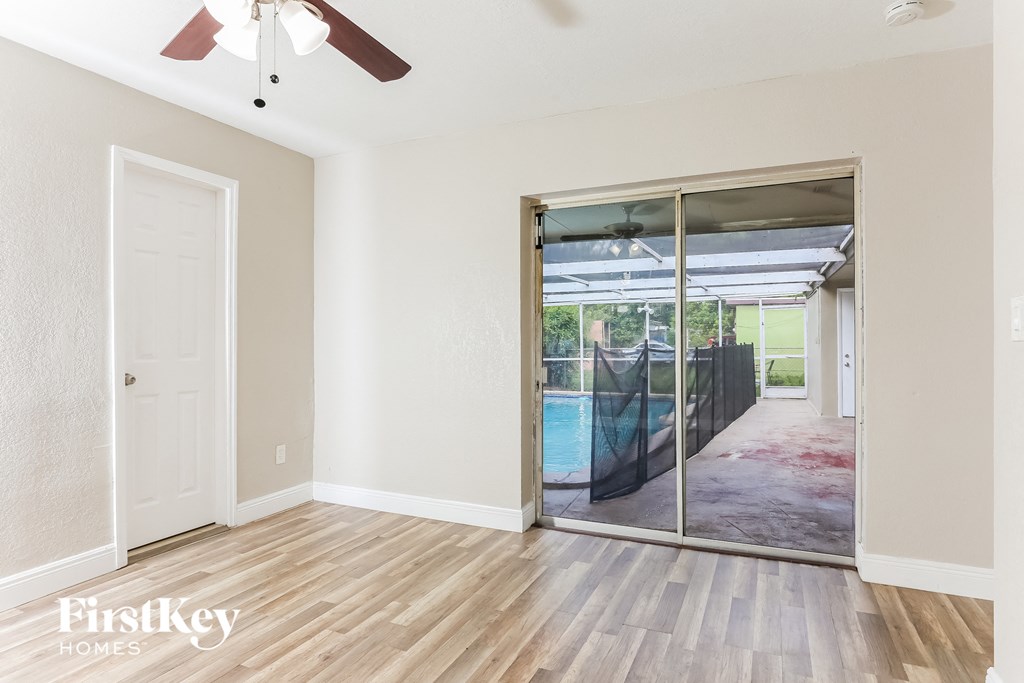 a living room with a sliding glass door to a pool