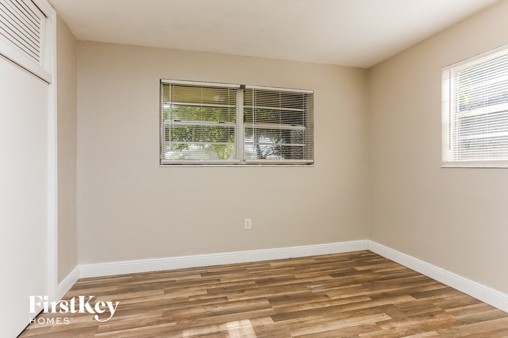 the living room of a home with wood floors and a window