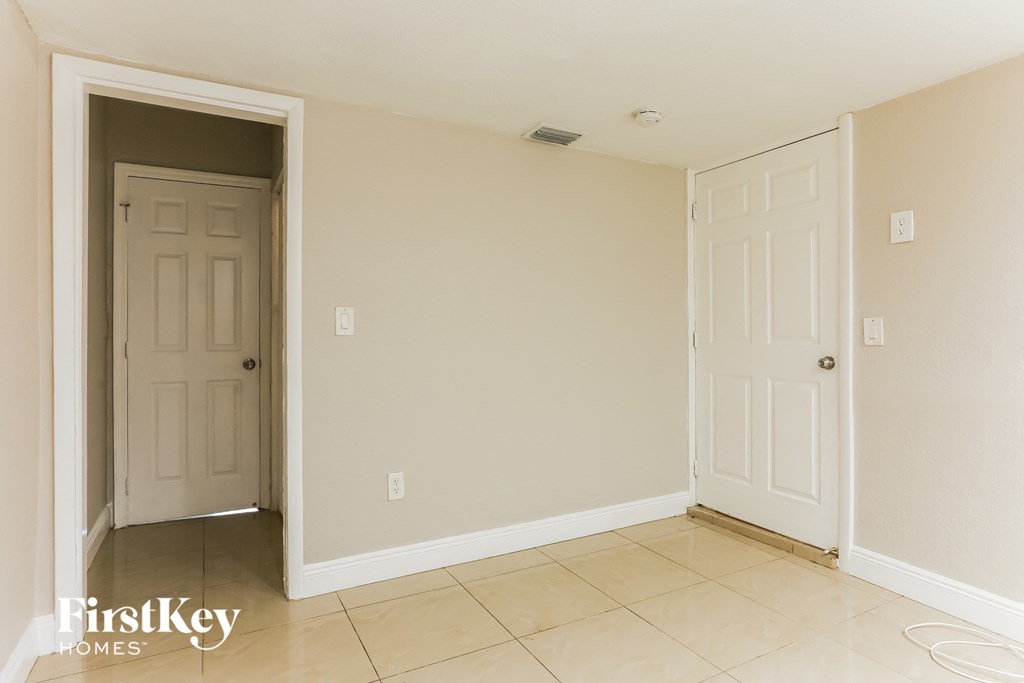 an empty room with two doors and a tiled floor