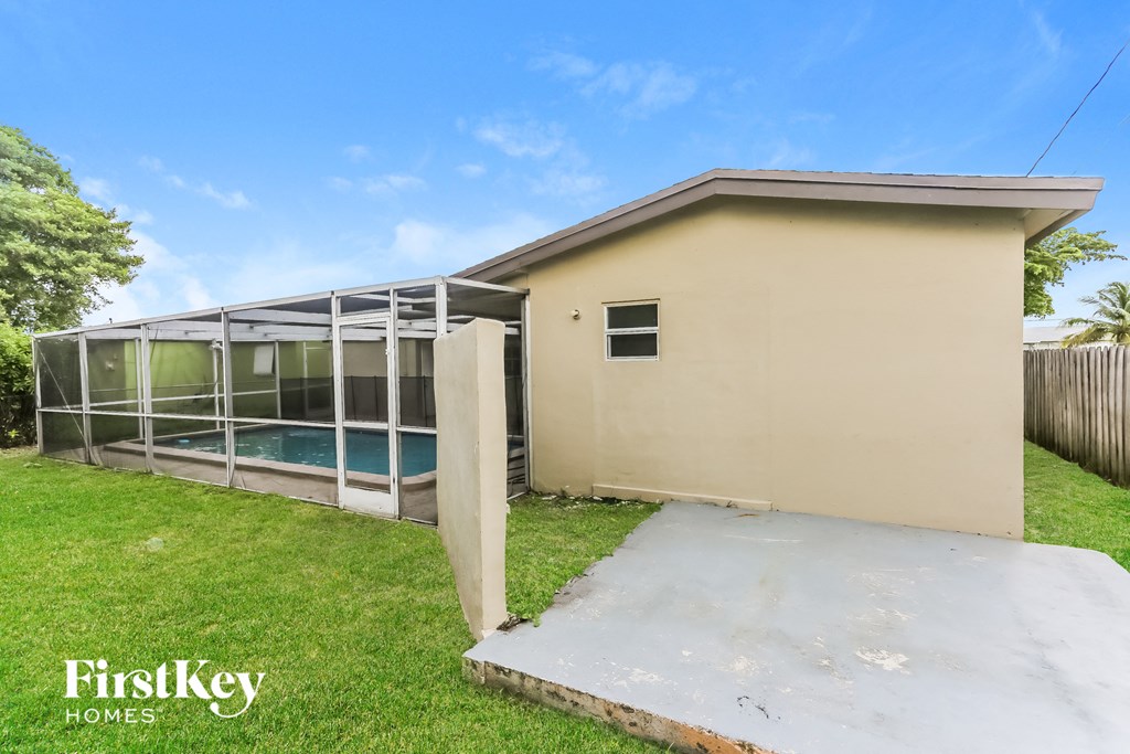 a backyard with a pool and a house with a greenhouse
