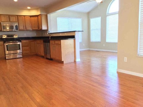 A kitchen with wooden cabinets and a black countertop.