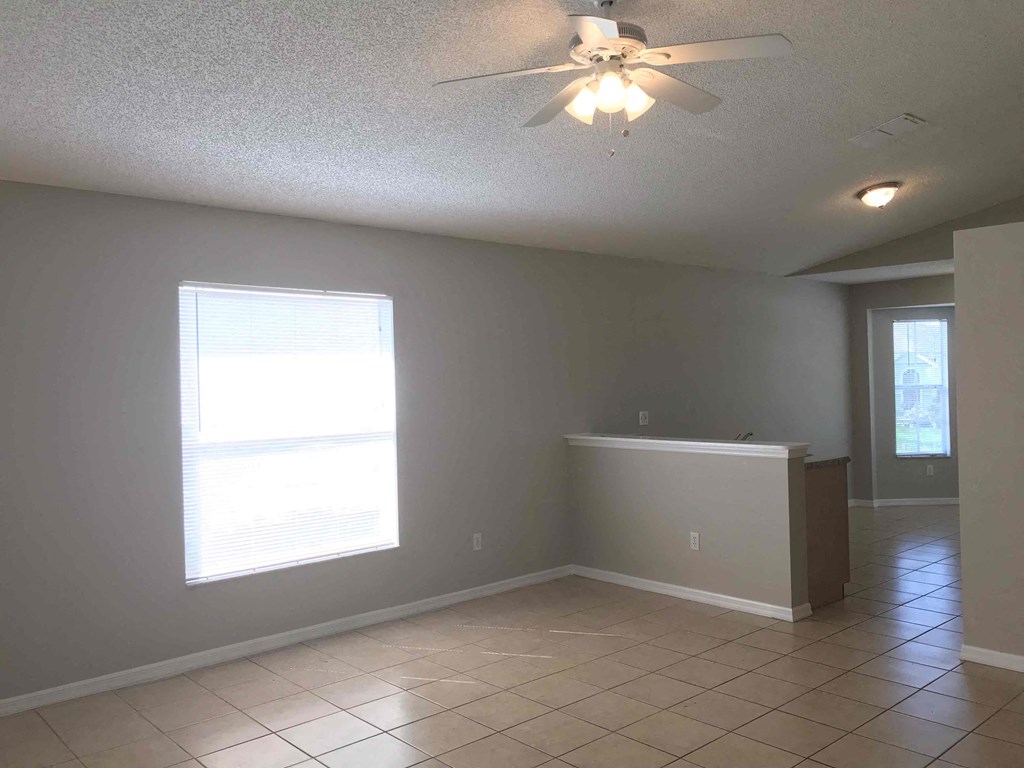 A room with a ceiling fan and tiled floor.