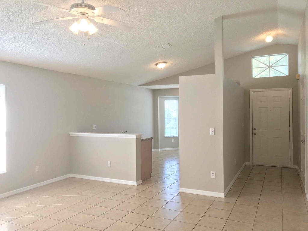 A room with a ceiling fan and tiled flooring.