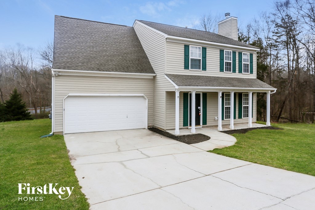 A two-story house with a garage and a driveway.