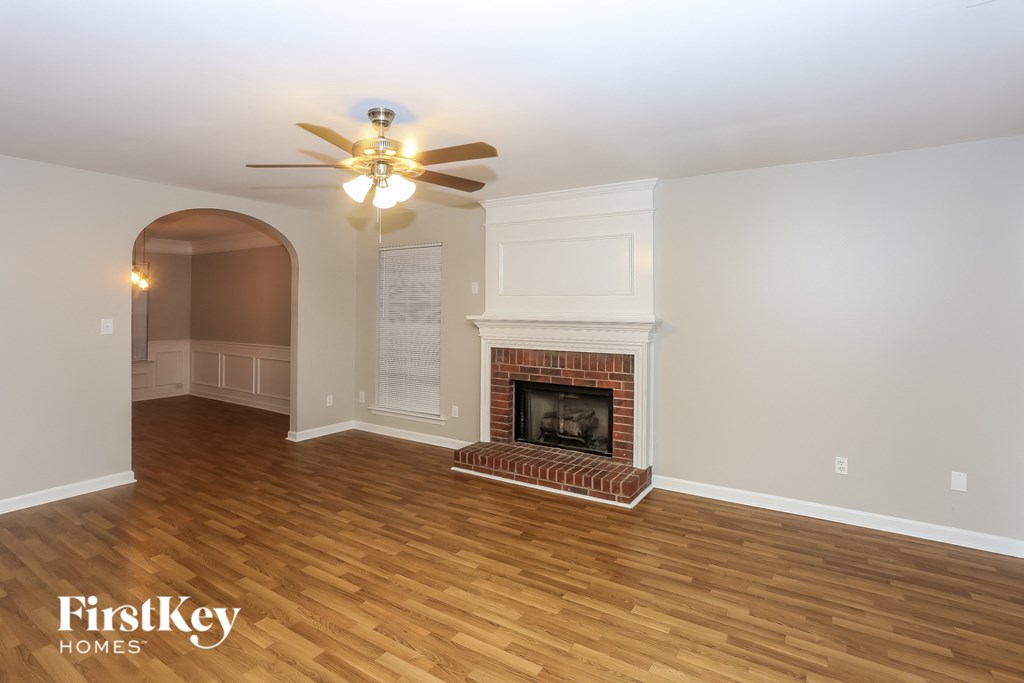 A room with a fireplace and a ceiling fan.