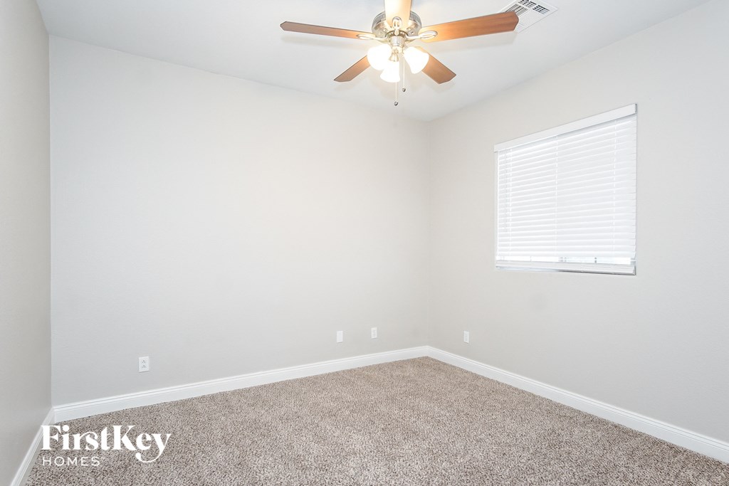 a bedroom with a ceiling fan and a window