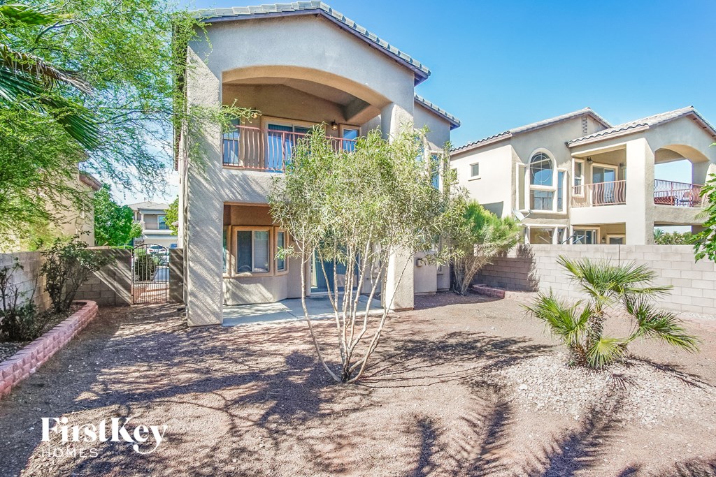 a house with a driveway and trees in front of it