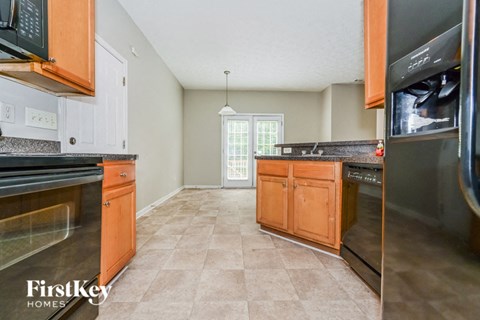 A kitchen with a tile floor and a refrigerator on the right.