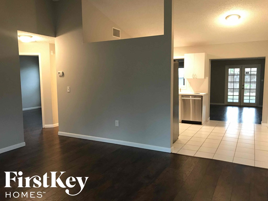 A room with a wooden floor and a white tile floor.