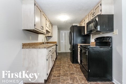 A kitchen with black appliances and wooden cabinets.