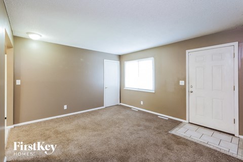 the living room of an empty house with a white door