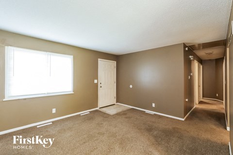 the living room of an empty house with a large window