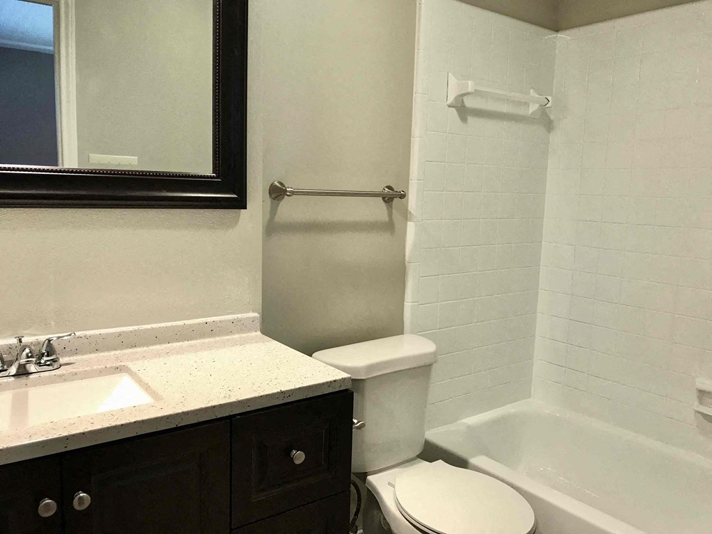 a bathroom with a toilet and a sink and a bath tub