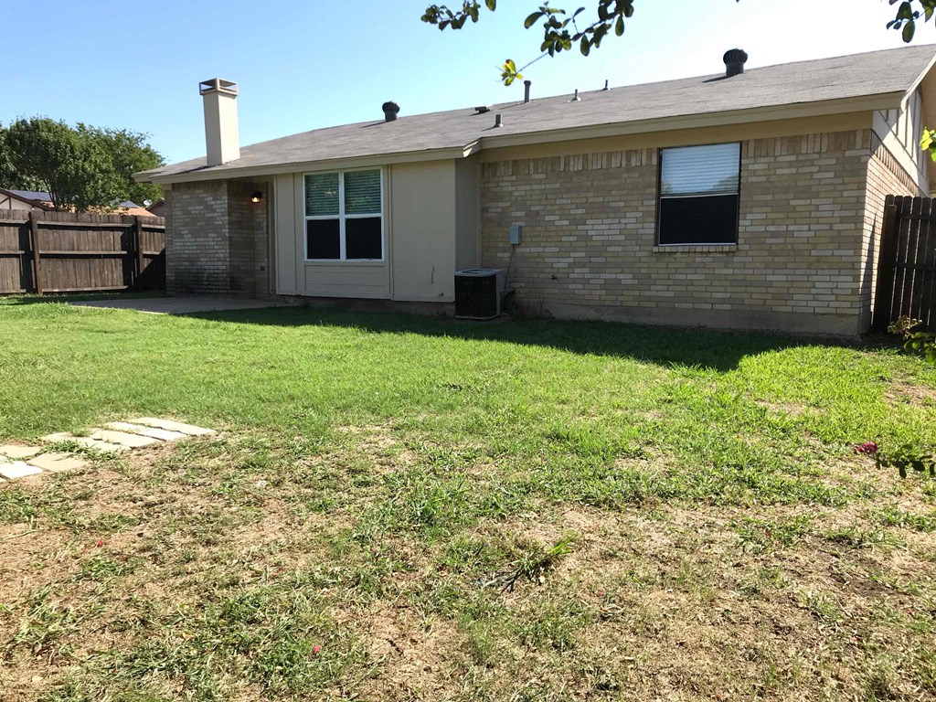 a view of the back of a house with a yard