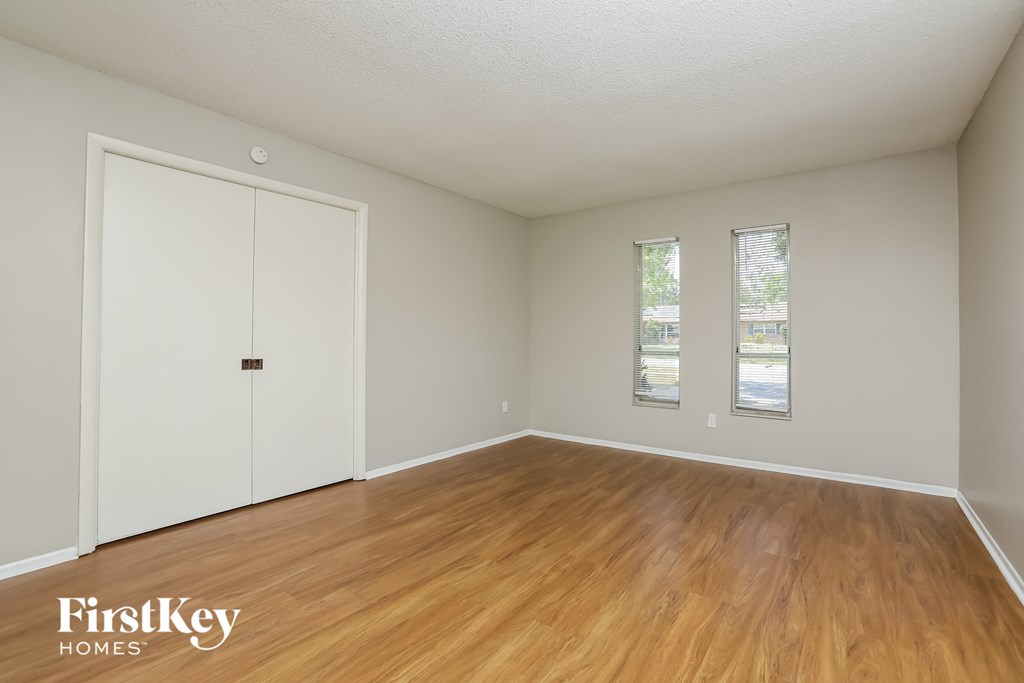 an empty living room with wood flooring and a white door